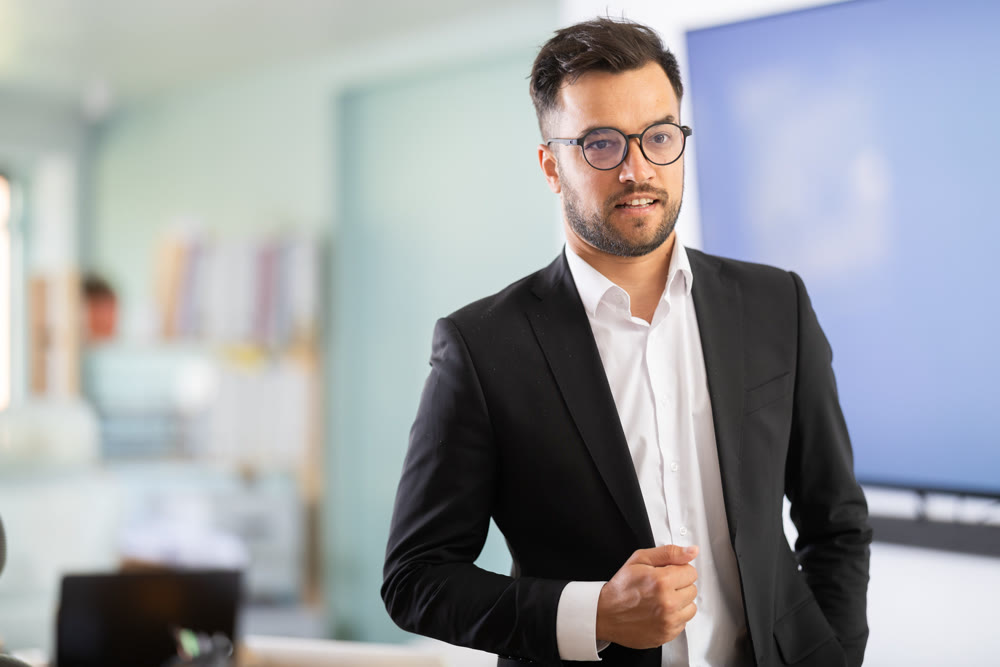 Man employee stands in office, in middle of working day