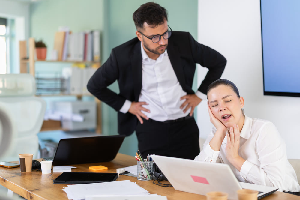 Female manager falls asleep at her desk. Boss scolds her for it