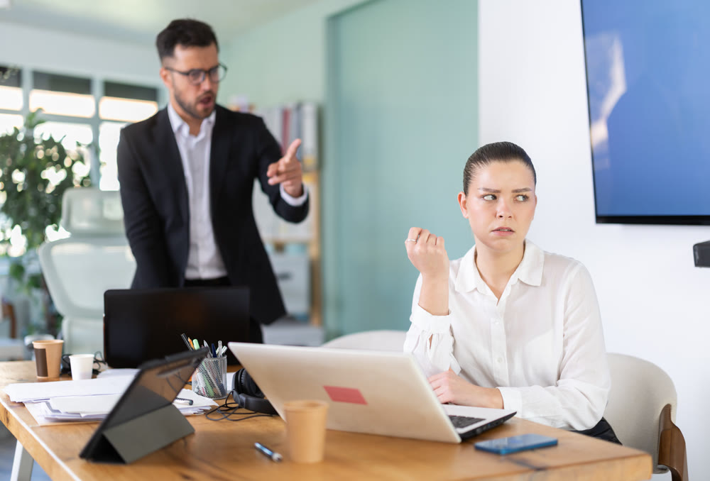 Male boss yells at woman employee, girl work at computer and reprimanded by management