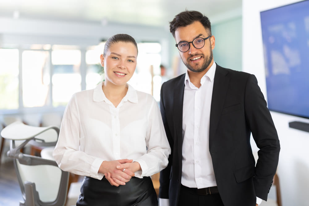 man and woman standing in the background of modern office