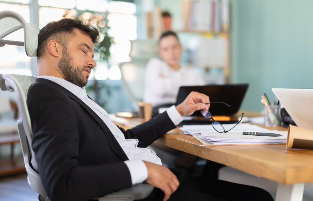 Tired man and girl sleeps next to computer at work