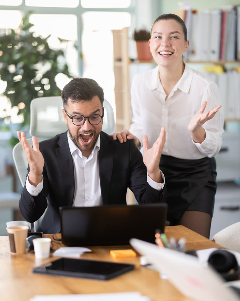 Man and a woman work in an office and are emotionally joy about the success in a new project