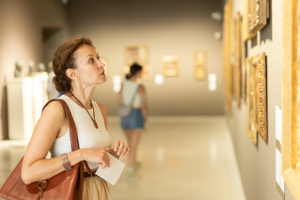 Woman looks at hall of paintings and sculptures