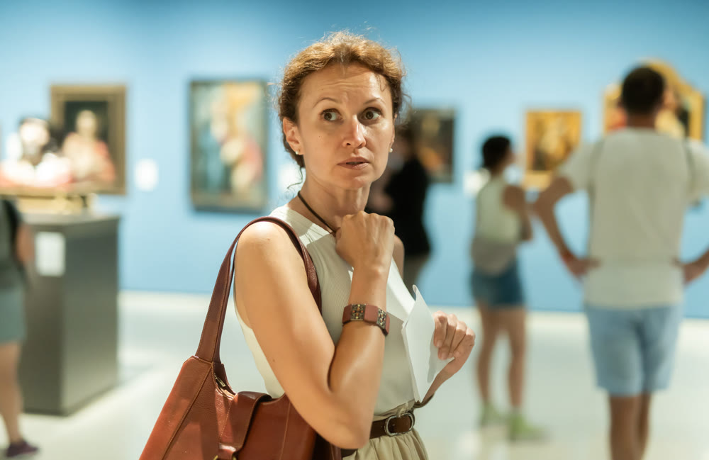 Woman looks at hall of paintings and sculptures
