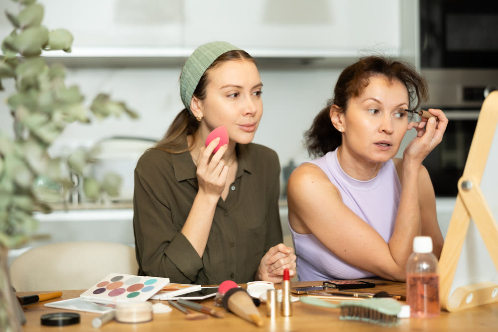 Two besties doing everyday makeup together in front of mirror