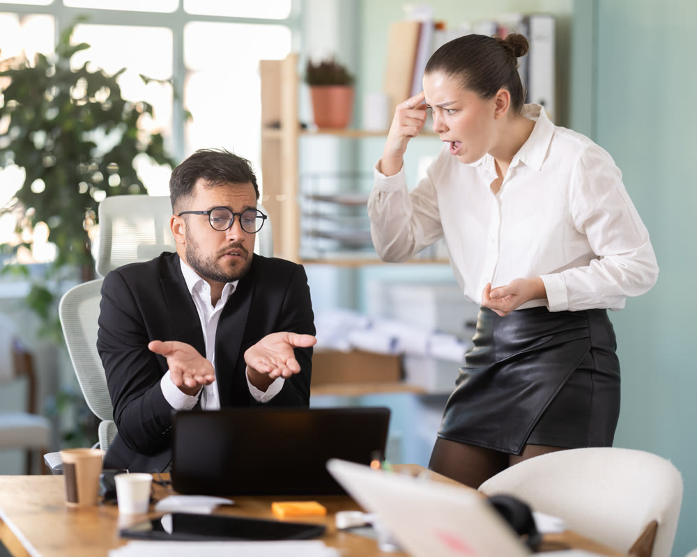 female boss stands in the office and scolds on a male IT department employee