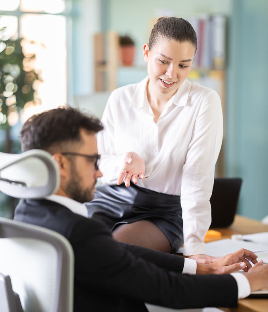 Adult business couple flirting at table at workplace in office