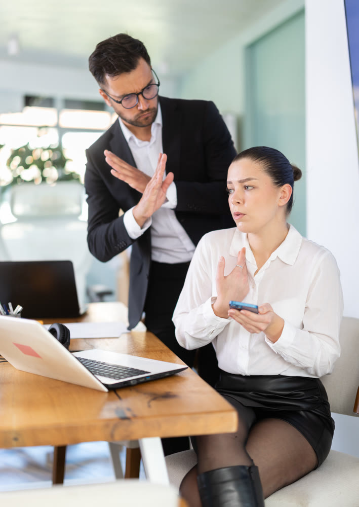 Businessman complains to subordinate about her talking on her mobile phone while working in office