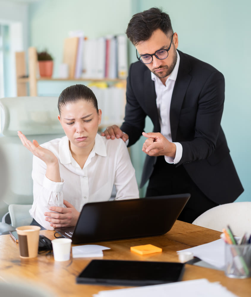 boss scolds at a woman who sits at the table and scrolls through social networks