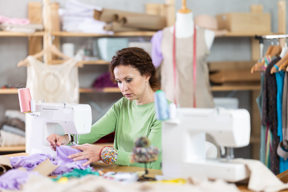 Woman tailor at work in cloth design shop