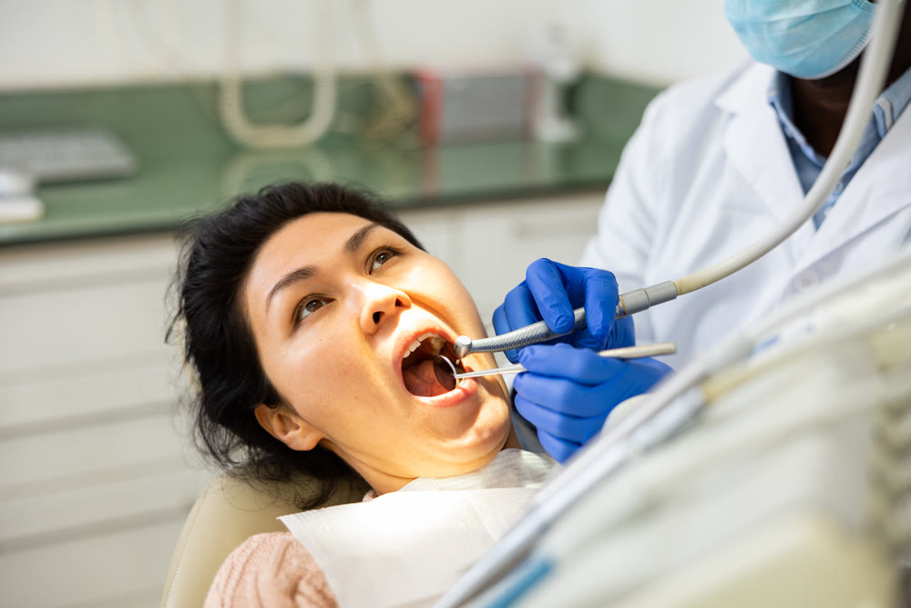 Woman receiving professional teeth treatment in dental office