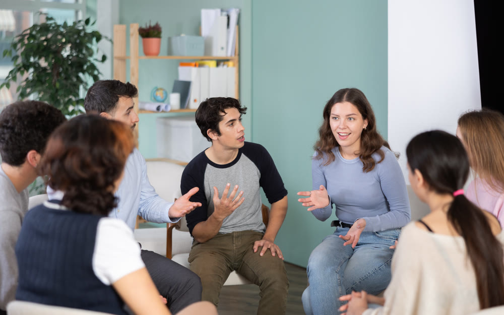 Students sitting in a circle and discussing a lecture
