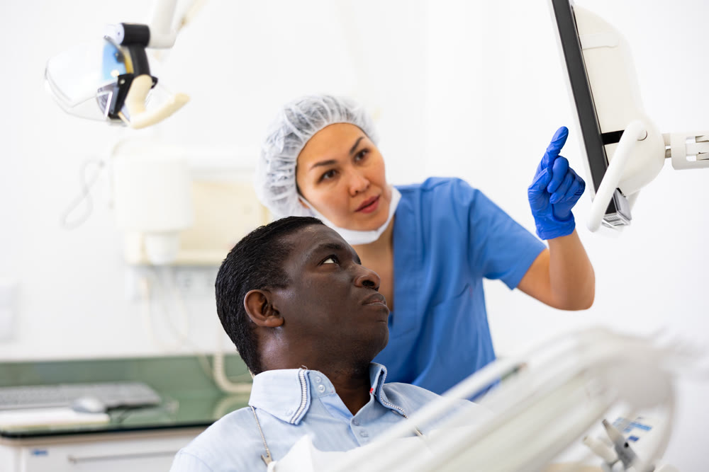 Female dentist explaining diagnosis to african american in dental office