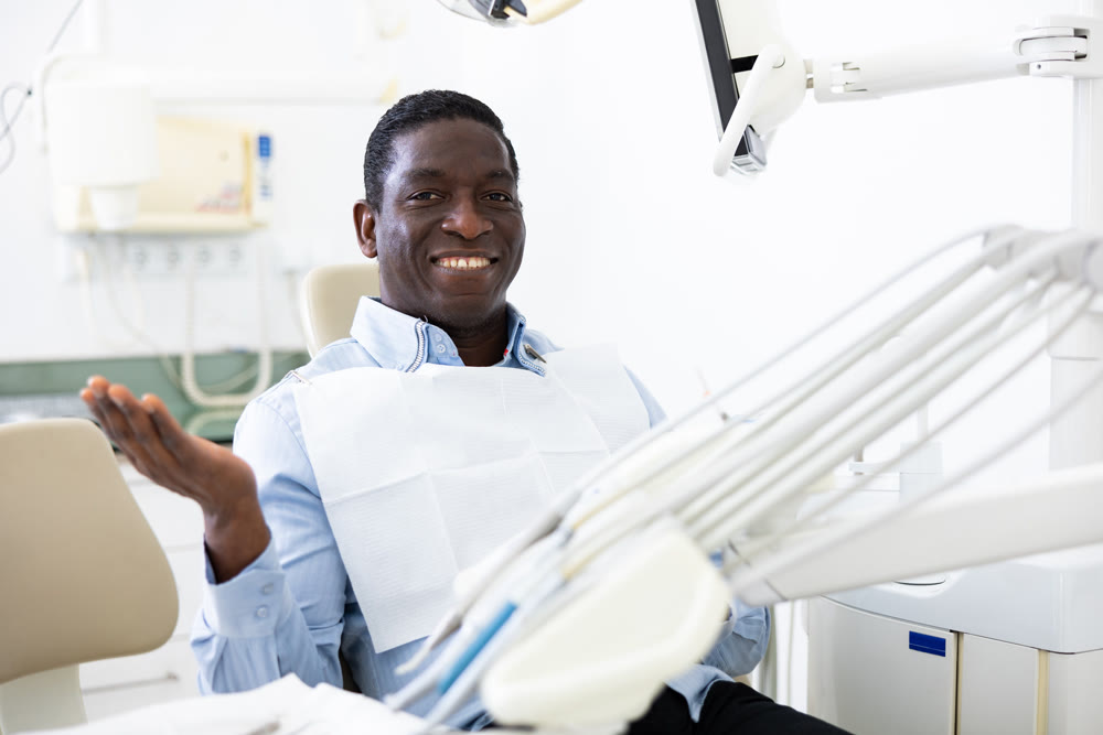 Portrait of smiling man patient sitting on dental chair