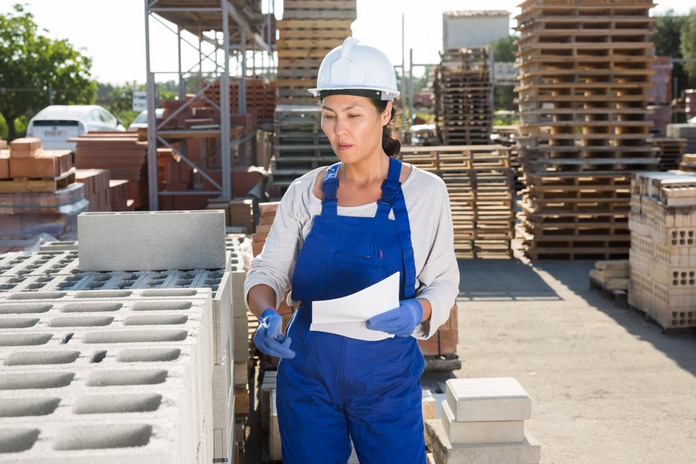 Asian woman worker keeps records of bricks