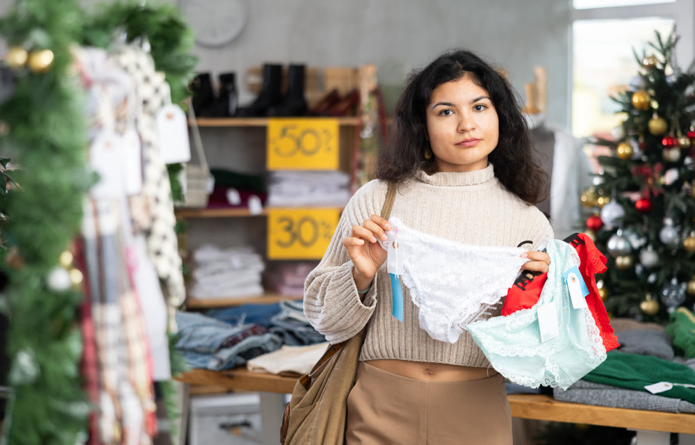 Female shopper selects panties in fashionable clothing boutique
