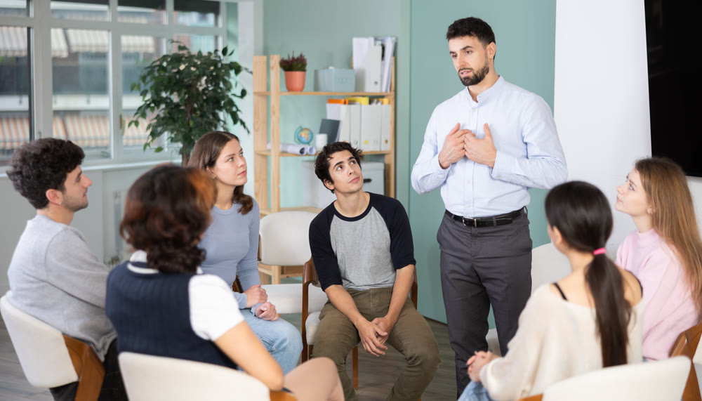 young man speaks to students in a classroom