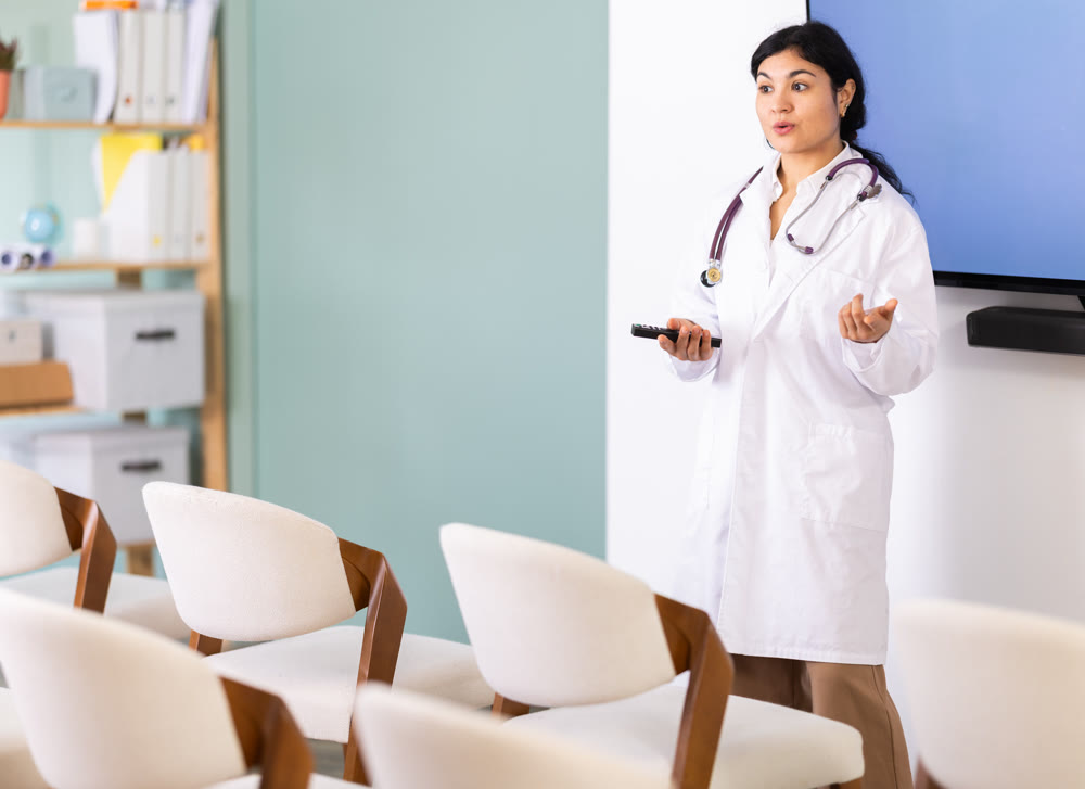 Woman doctor with remote control in lecture hall