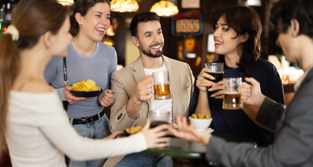 Group of friends happily having time at bar