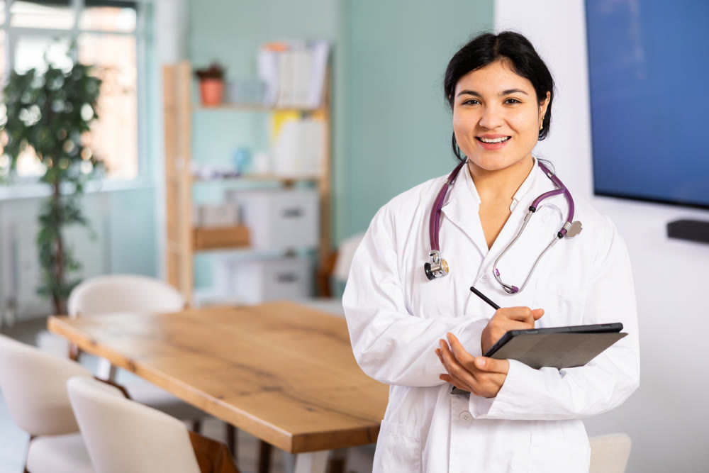 Doctor woman with tablet stands in office space