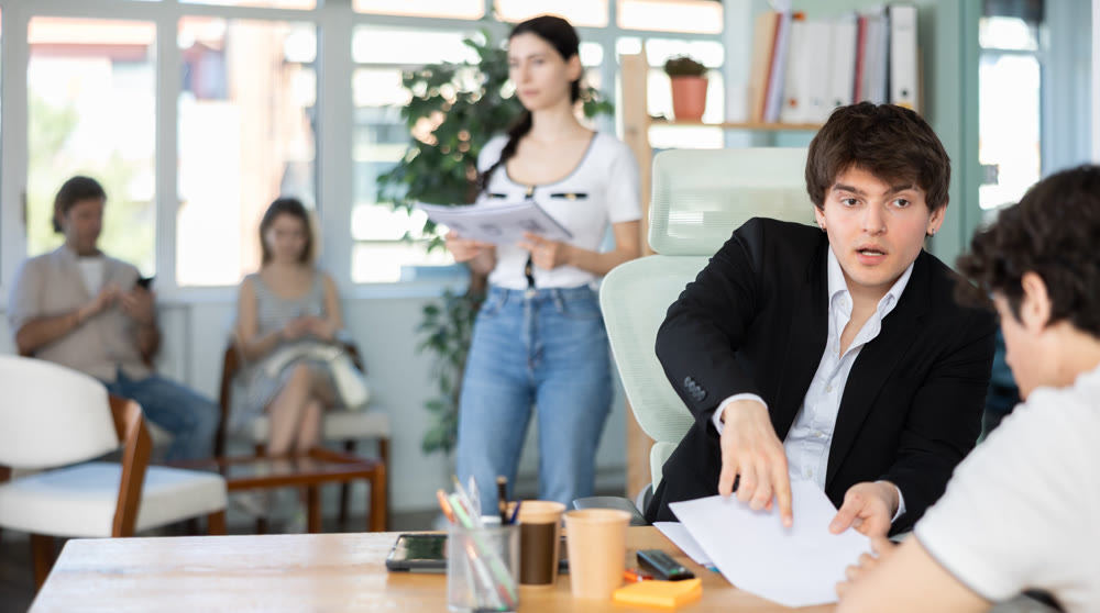 Male bank manager discusses loan terms with young man
