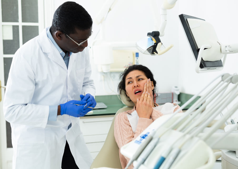 Asian woman talking with dentist about toothache
