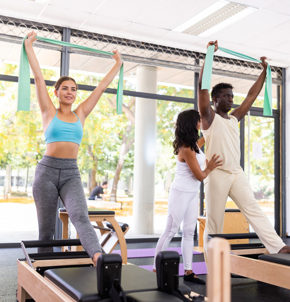 Active woman and man who care about their health training muscles with resistance bands with instructor