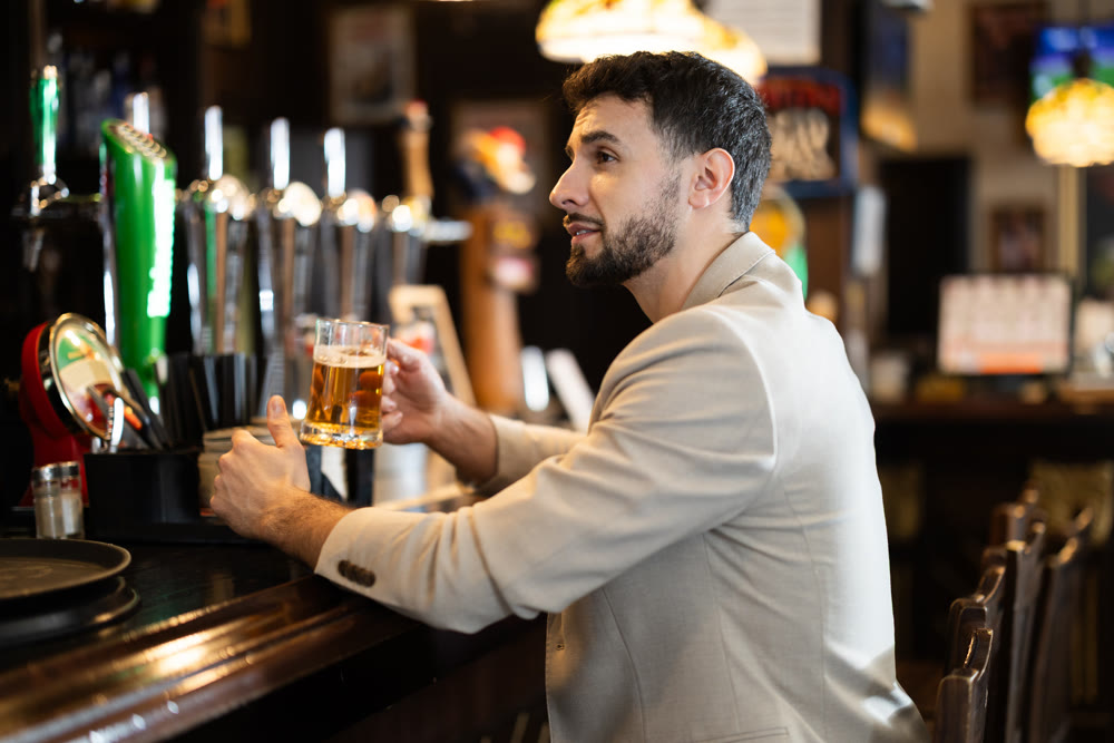 Portrait of man with glass of beer in nightclub or bar