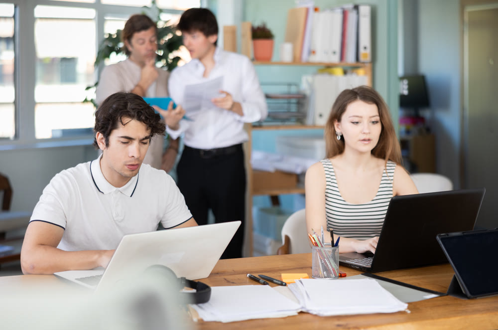 Managers sitting at desk is working on laptop computer.