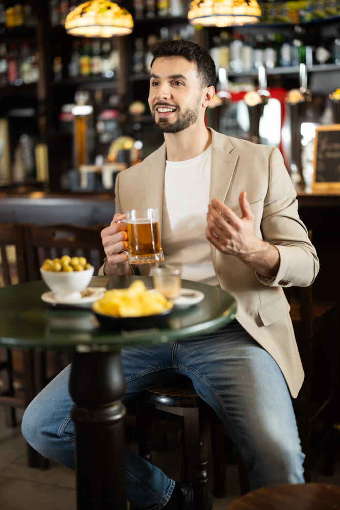 Portrait of man with glass of beer in nightclub or bar