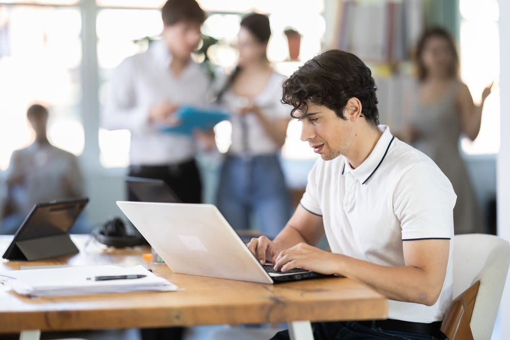 Young man working on laptop in modern office