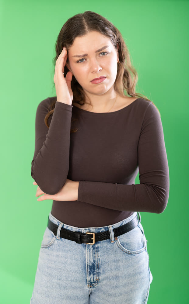 Young woman sad and upset in front of green screen