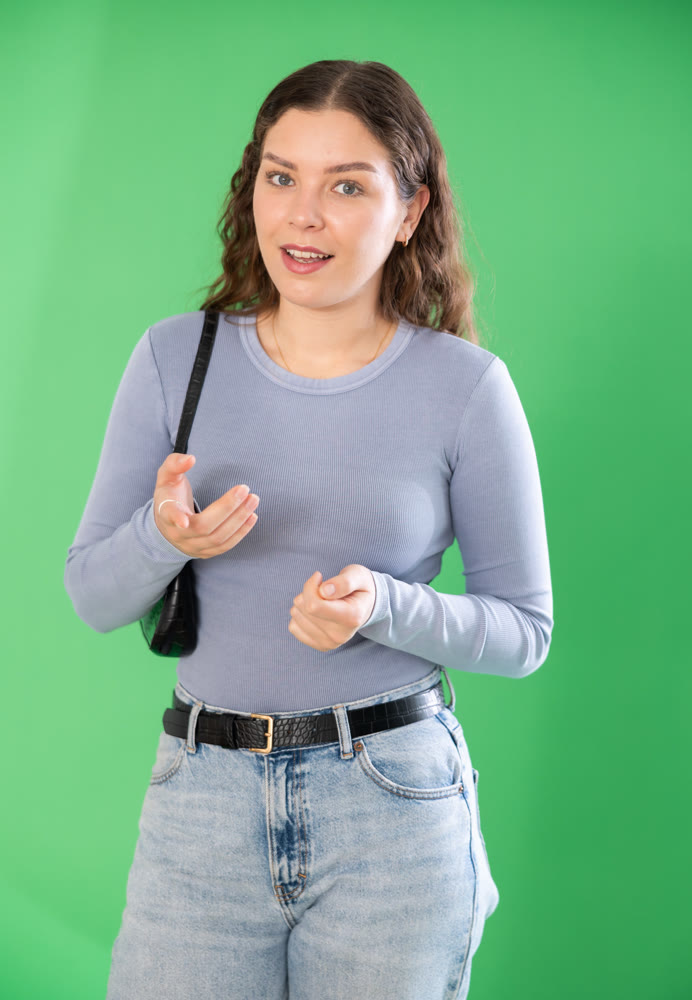 Young woman talking in front of green screen