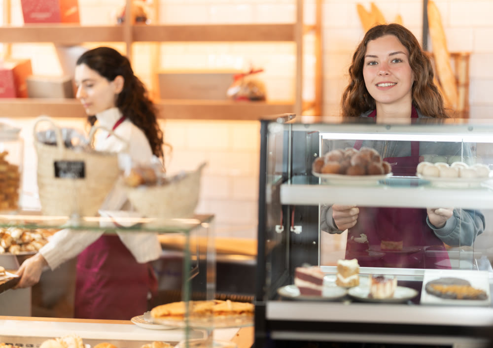 Woman seller offering pastries in a cafe