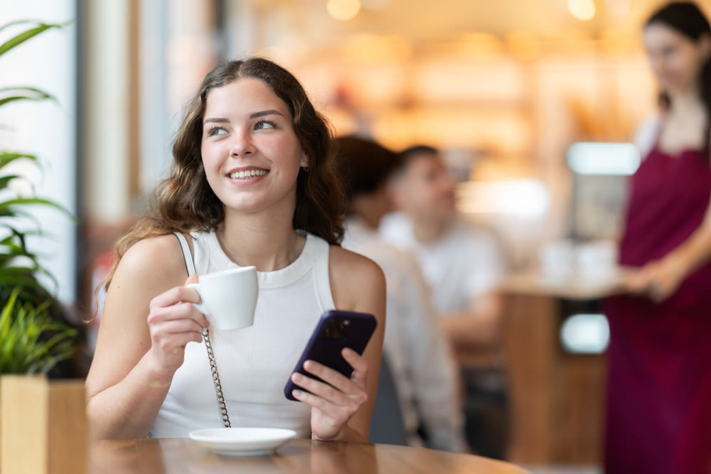 Young woman with phone in cafe