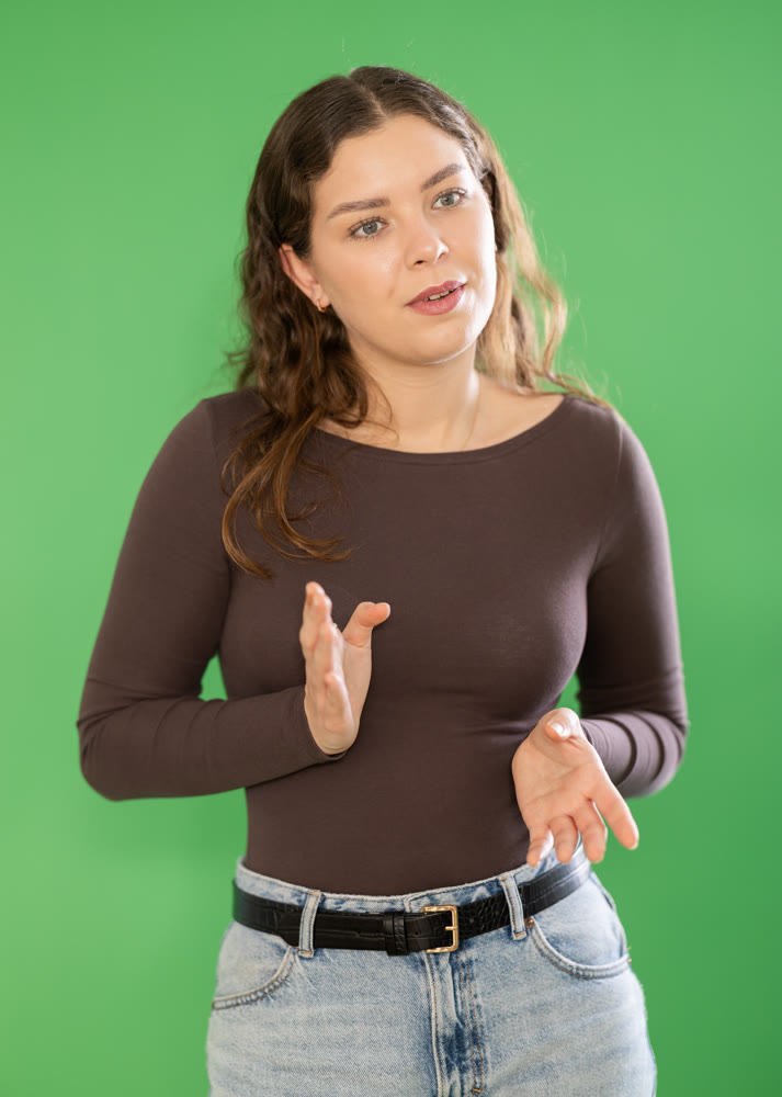 Young woman talking in front of green screen