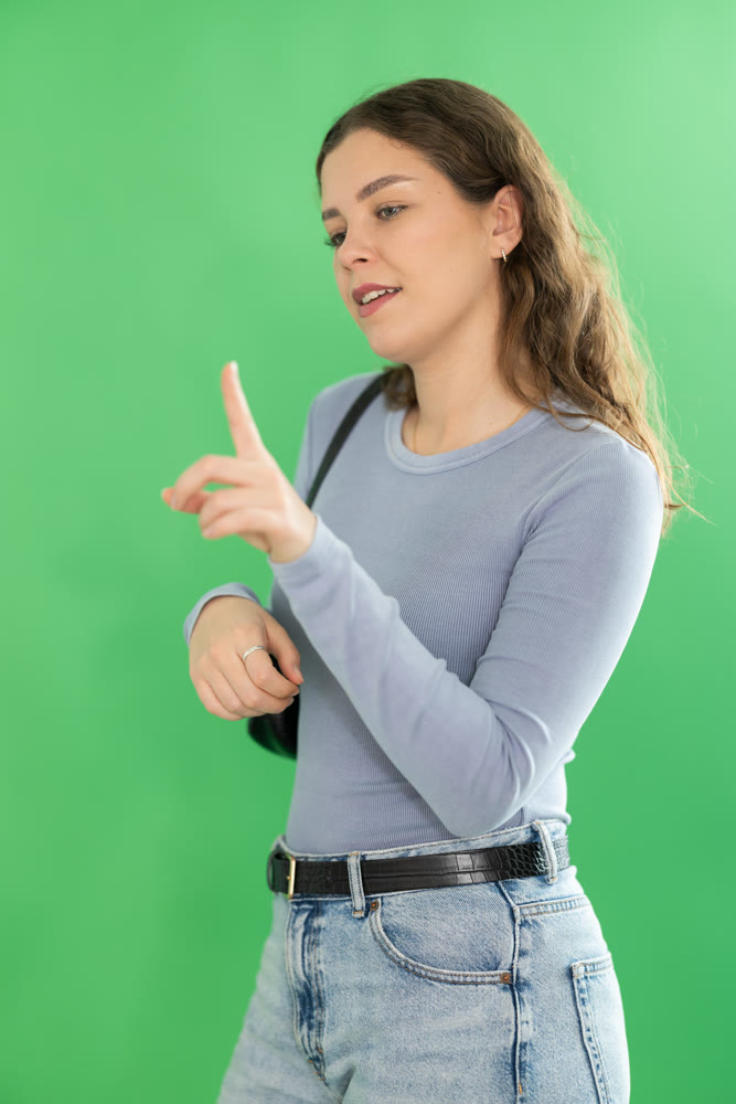 Young woman using virtual screen in front of green screen