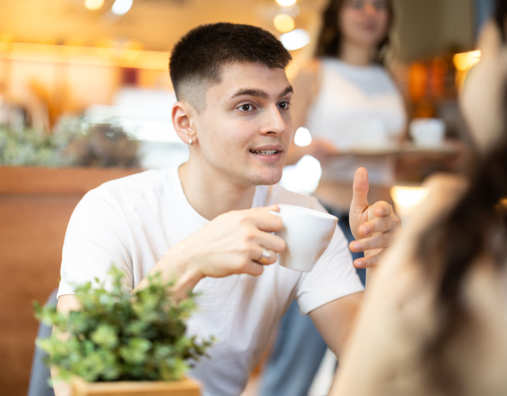 Guy chats with a woman in a coffee shop
