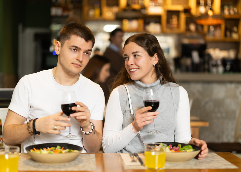 Couple sitting in a restaurant, chatting and drinking wine