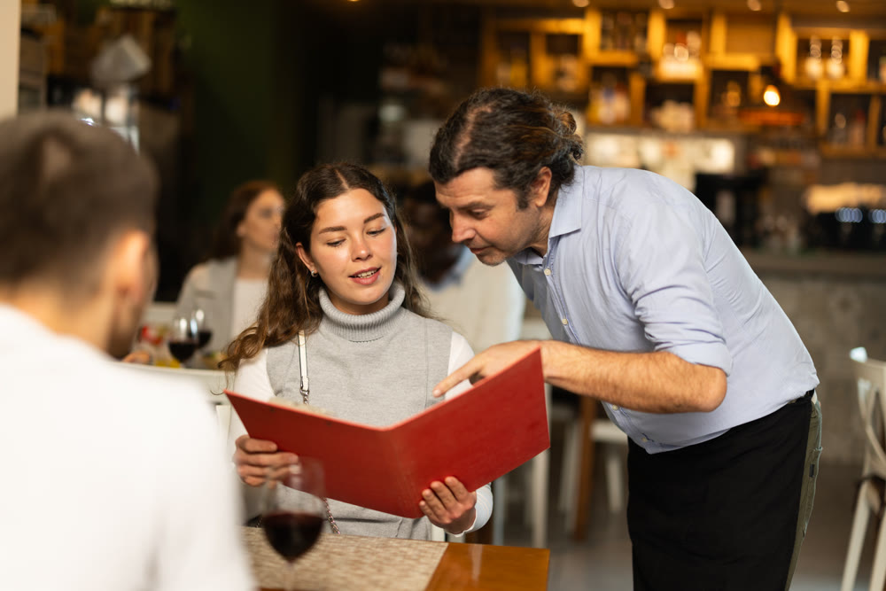 male waiter talks about the dish of the day in a restaurant