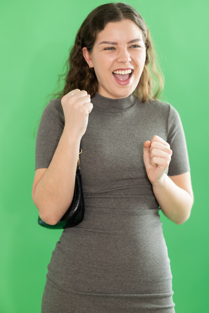 Portrait of girl expressing happy emotions on green background