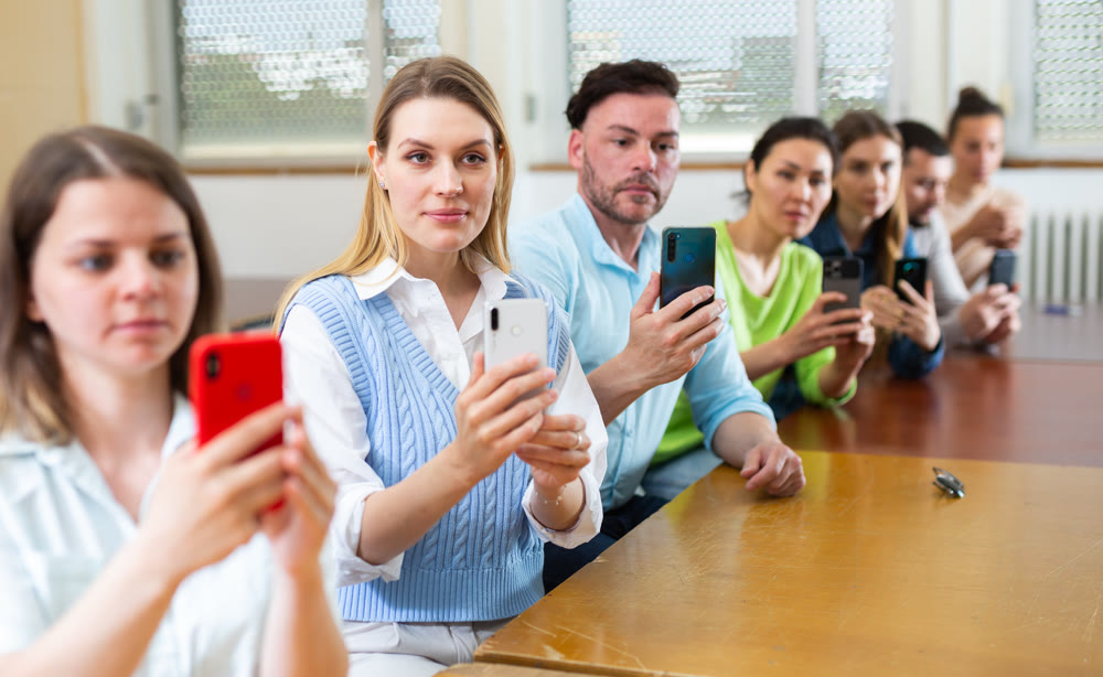 Fellow students are taking photo with smartphone cameras