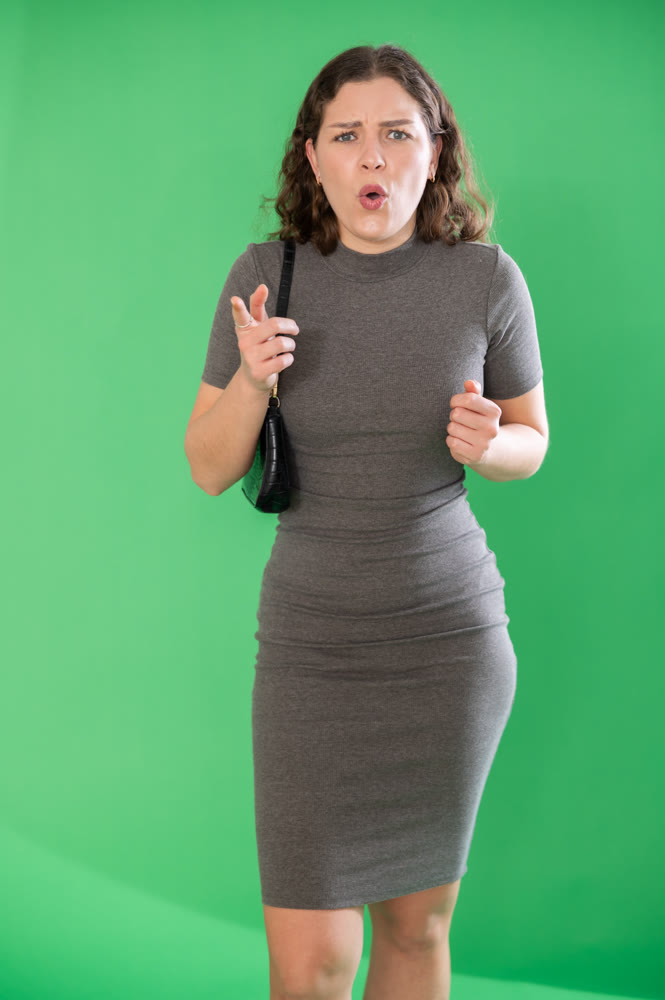 Young woman angry and yelling in front of green screen
