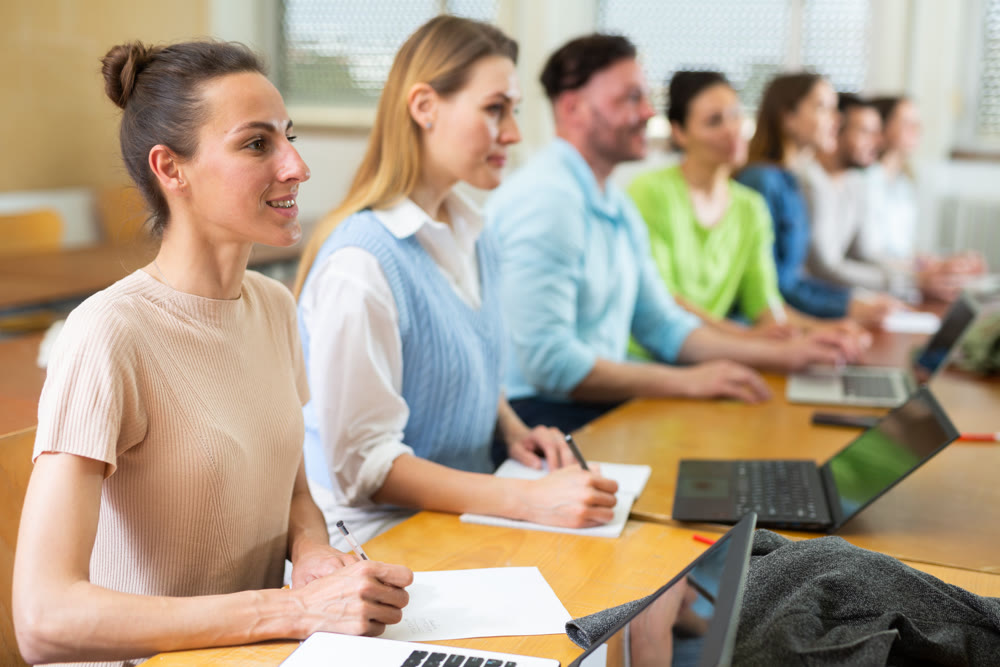 Group of students attentively listening to lecture in university classroom