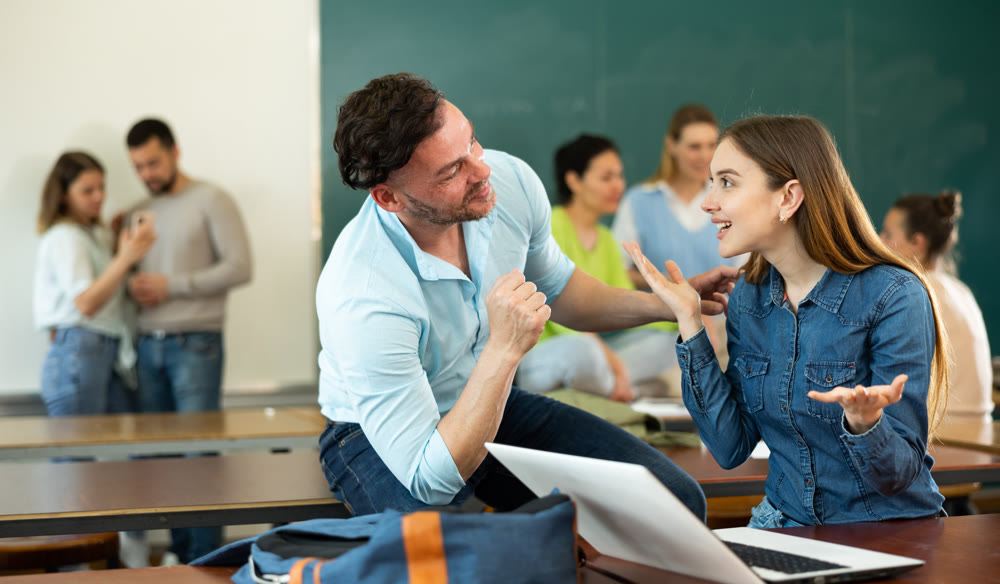 Man and woman students having small talk in classroom