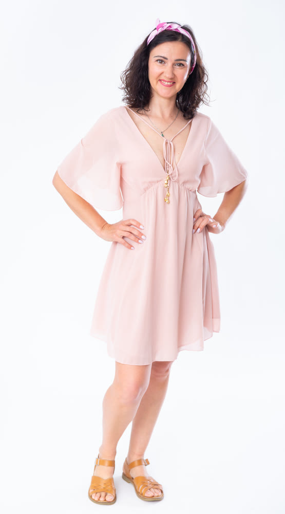 Portrait of an attractive adult woman in a pink dress on white background
