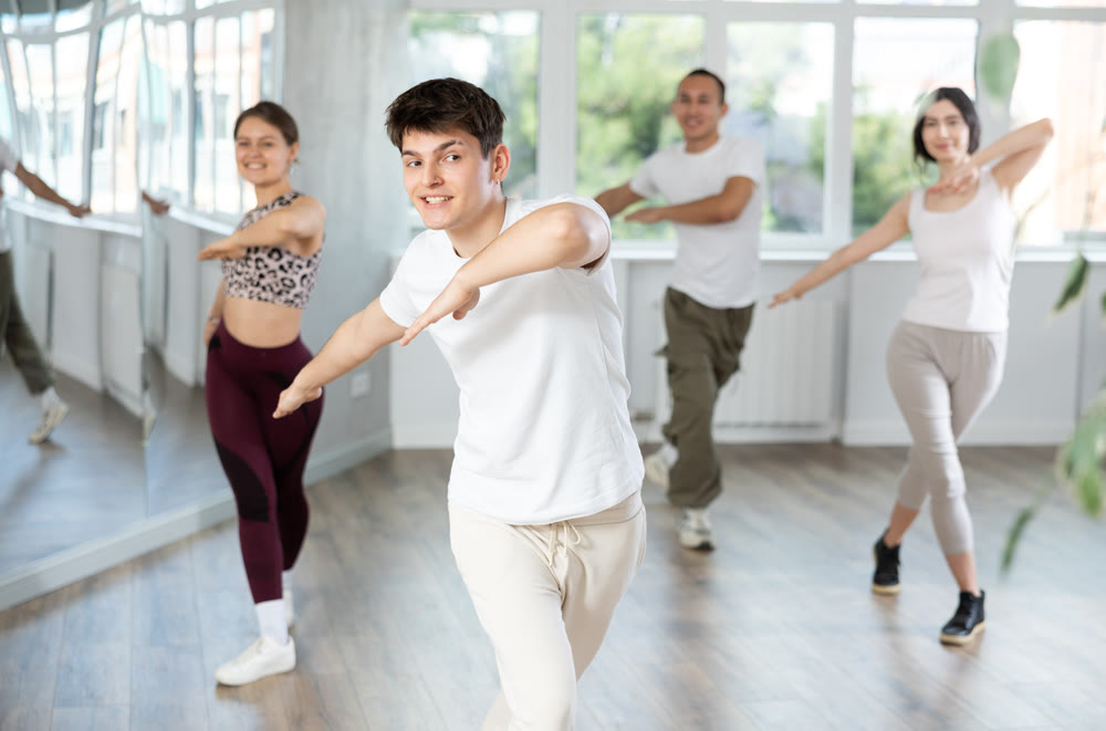 Young Hispanic guy enjoying energetic dance at group class