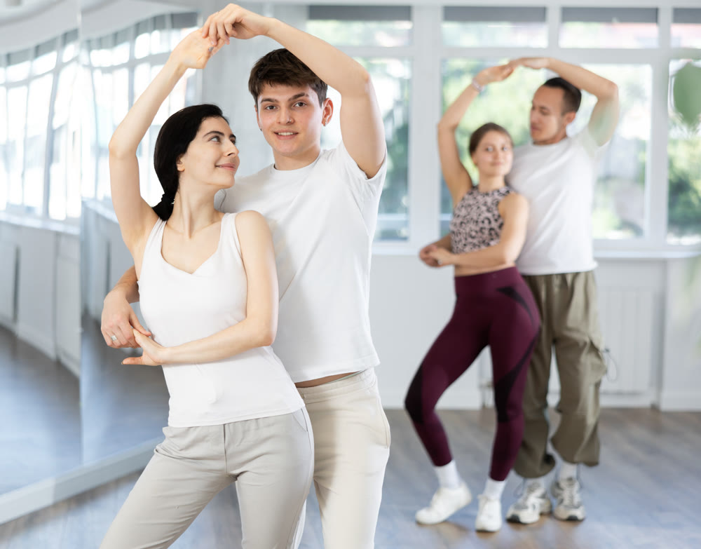 Girl paired up with young man, they train to perform disco fox dance, rehearse performance.