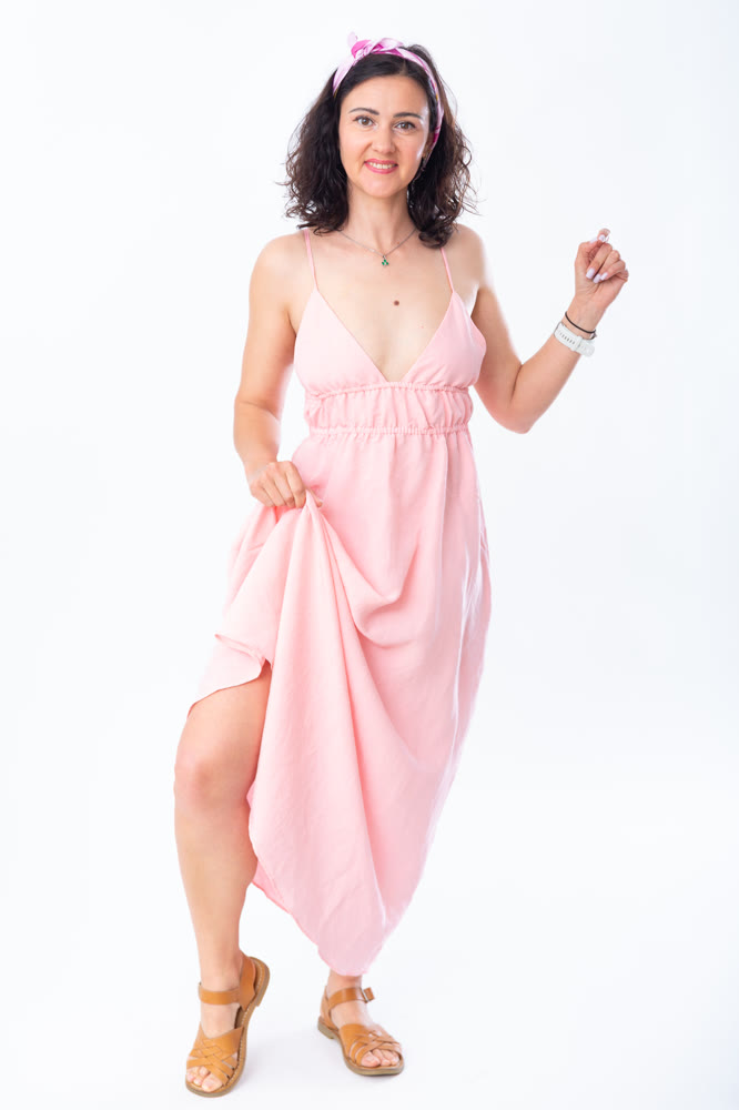 Portrait of an attractive adult woman in a pink dress on white background