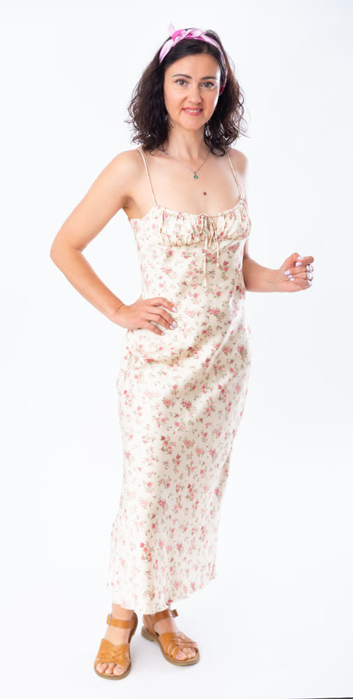 Portrait of an attractive slim woman in long summer dress on white background
